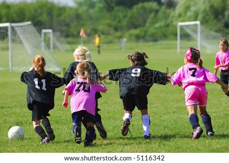 Two Girl\'s Soccer Teams race for the ball.