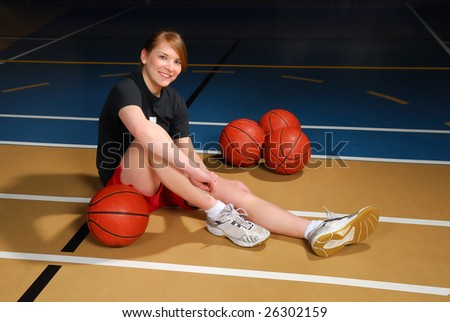 A teenage student rests on the basketball court