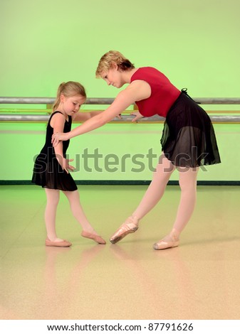 A Ballet Teacher Helps a Girl Dance Student with her lesson