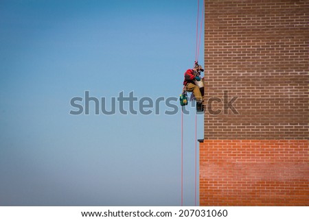 Steeplejack Builder worker plastering industrial building facade