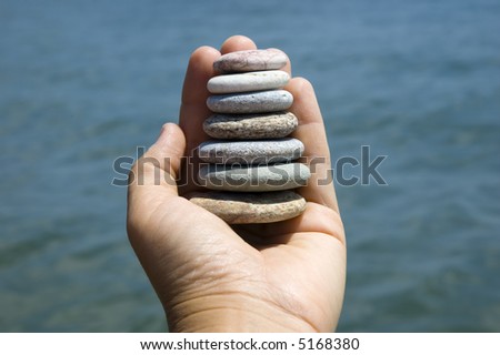 Pebbles in a hand near the ocean