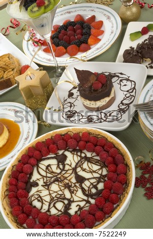 Elegant table with many desserts and fruits ( pecan swirl cake, raspberry pie, rice pudding, cheese cake, creme caramel and more)