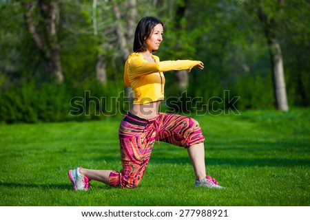 Push ups or press ups exercise by young woman. Girl working out on grass crossfit strength training in the glow of the morning sun against a white sky with copyspace. Mixed race Asian Caucasian model.