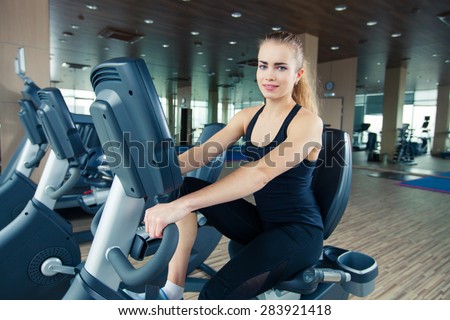 beautiful girl doing indoor biking in a fitness club