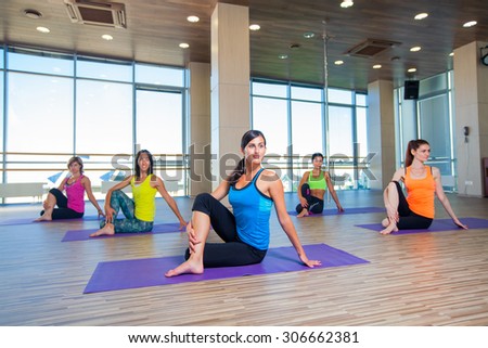 fitness, sport, training and lifestyle concept - group of smiling women stretching in gym.