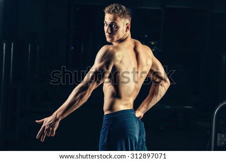 Silhouette of a athlete. Confident young fitness man with strong hands. Dramatic light