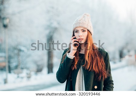 Young  woman smiling with smart phone and winter landscape