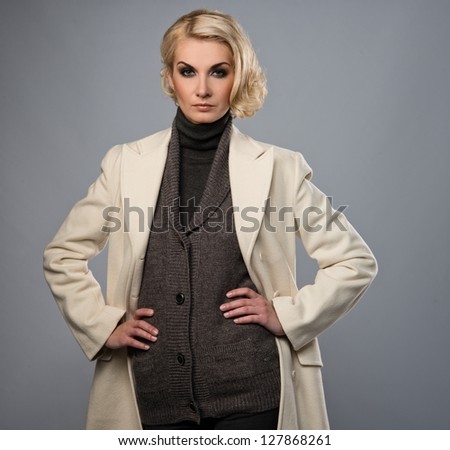 Elegant woman in white coat isolated on grey