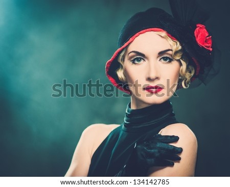 Elegant blond retro woman  wearing little hat with red flower