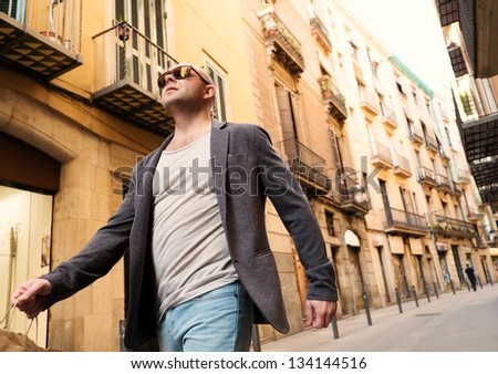 Middle-aged man with shopping bag walking outdoors