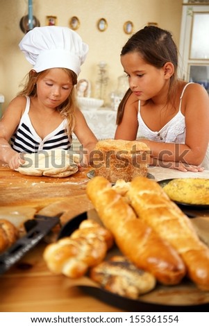 Two little girls trying to cook homemade pastry