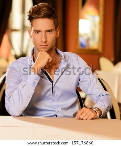 Handsome young man alone in a restaurant