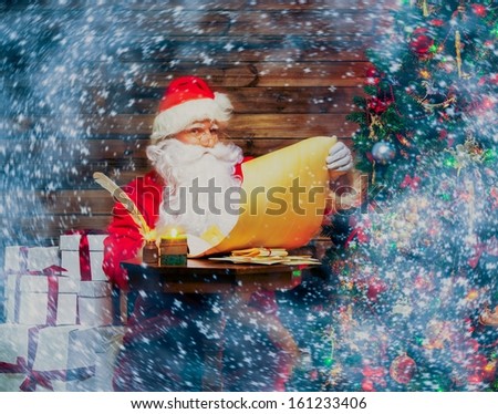 Santa Claus in wooden home interior reading wish list scroll