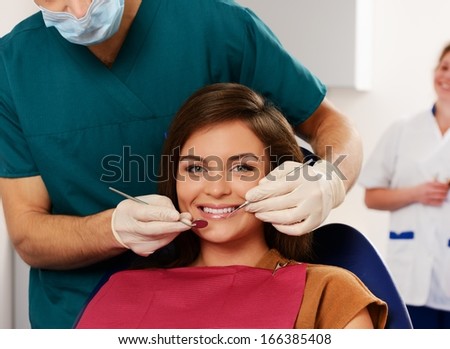 Young woman and man doctor with his assistant at dentist\'s surgery