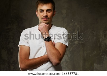 Handsome young man in white t-shirt on grunge background