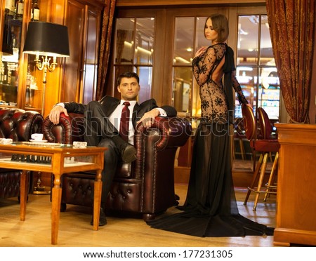 Elegant couple in formal dress in luxury cabinet interior