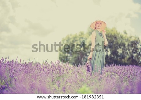 Woman in long green dress and hat in a lavender field