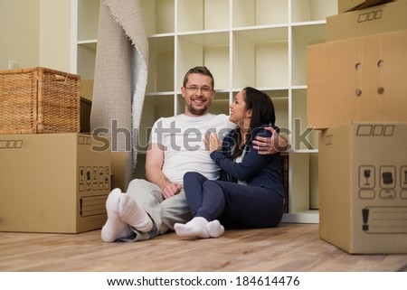 Young positive couple  among boxes in their new home