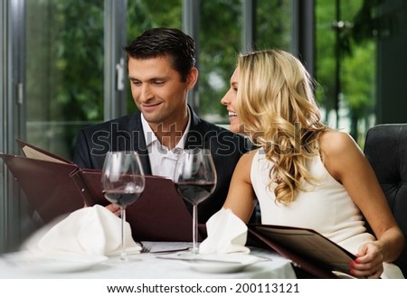 Cheerful couple with menu in a restaurant