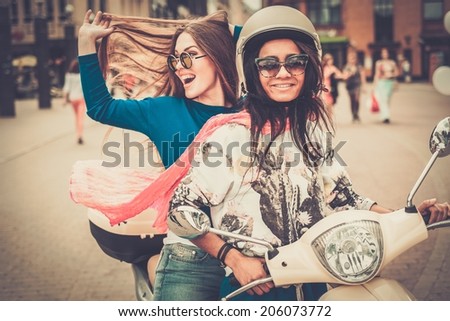 Multi ethnic girls on a scooter in european city