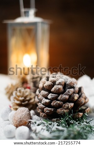 Christmas still life with cones and lantern on a snow