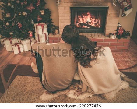 Couple near fireplace in Christmas decorated house interior