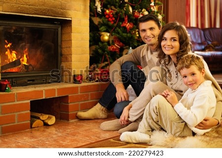 Family near fireplace in Christmas decorated house