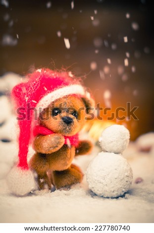 Small toy bear making snowman in christmas still life