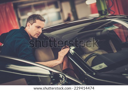 Man worker polishing car on a car wash