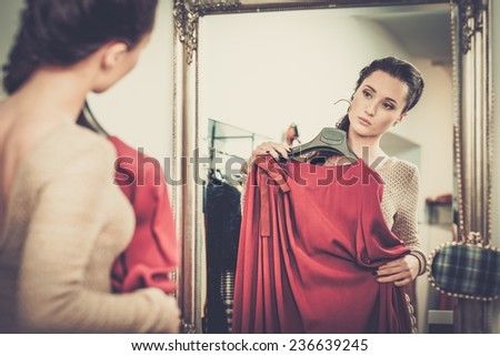 Young woman choosing clothes in a showroom