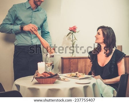 Beautiful young lady and waiter in restaurant