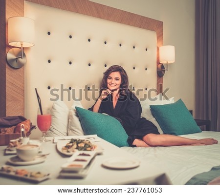Beautiful woman having breakfast in a hotel room