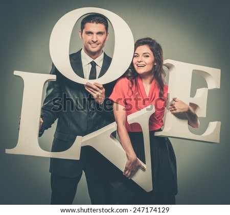 Couple holding word LOVE made from foam plastic