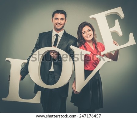 Couple holding word LOVE made from foam plastic