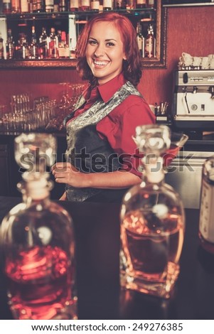 Beautiful redhead barmaid behind bar counter