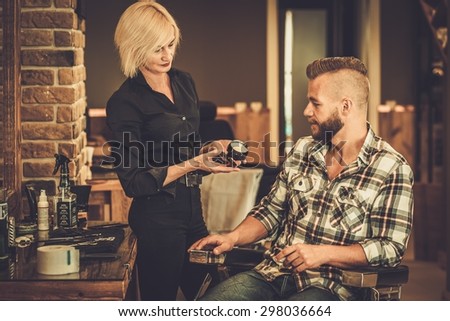 Client choosing hair care product in a barber shop
