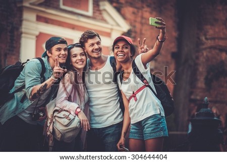 Multiracial friends tourists making selfie in an old city