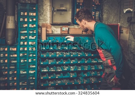 Mechanic near shelves with bolts and nuts