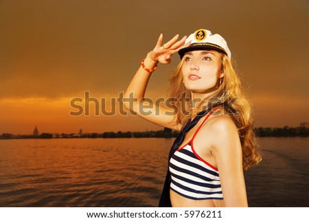 Beautiful girl in captain\'s hat looking for someone