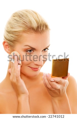 Beautiful young woman applying make-up to her face