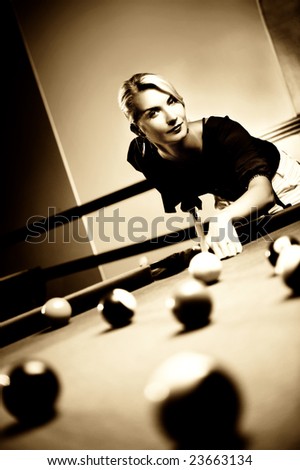 Beautiful blond woman playing billiards (toned in sepia)