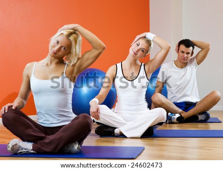 Group of people doing yoga exercise (focus on woman in the middle)