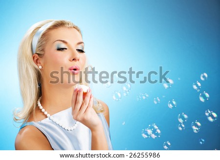 Beautiful young woman blowing soap bubbles