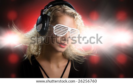 Beautiful young woman with headphones in nightclub