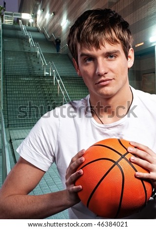 Young basketball player outdoors at night time