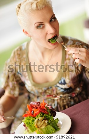 Beautiful woman eating salad in a restaurant