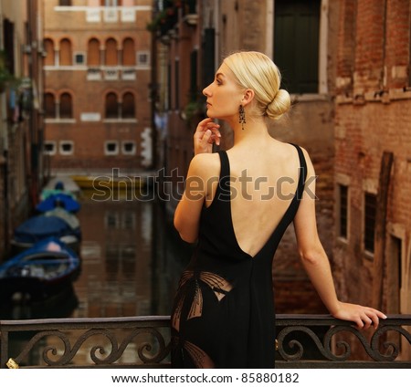 stock-photo-beautiful-woman-in-black-dress-on-a-bridge-85880182.jpg