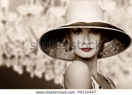 Woman in hat on vintage crystal lamp background.