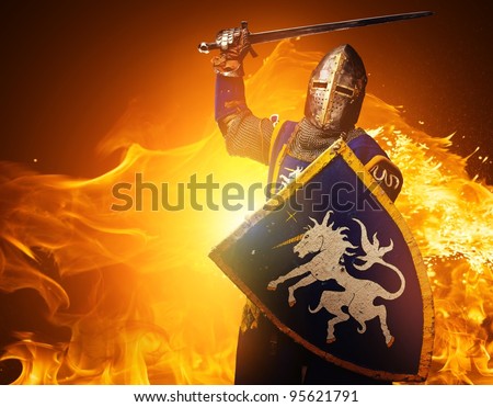 Medieval knight in attack position on fire background.
