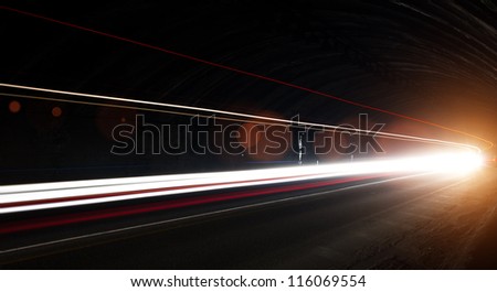 Truck light trails in tunnel. Art image with lens flares . Long exposure photo taken in a tunnel